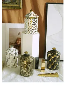 Lidded ceramic candle jars with geometric patterns and golden handles for home decor