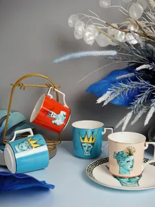 Dettaglio di tazze in ceramica artistica con ritratti greci e piattini coordinati
