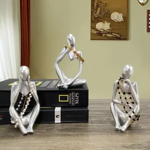 Silver abstract thinker sculpture set used as jewelry holders on vintage books