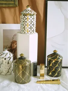Detailed view of four geometric ceramic scented candle jars with gold and silver patterns