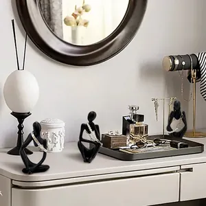 Detail of matte black abstract resin figure sculptures used as jewelry displays