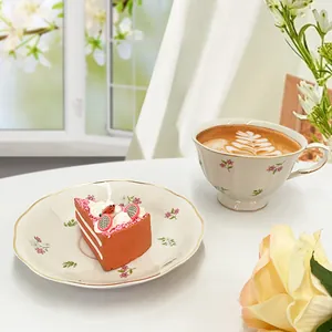 Floral ceramic teacup and saucer set with gold rim and elegant pastel flower patterns