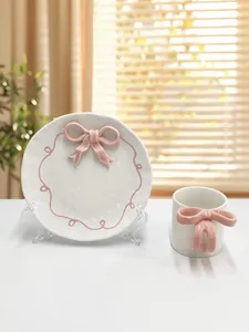 Dettaglio del set da colazione in ceramica con fiocco rosa 3D e bordo a onde rosa