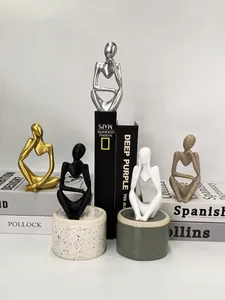 Detailed view of resin thinker statues in gold and silver finish for office decor