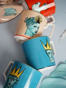 Dettaglio di quattro tazze in ceramica colorate con ritratti greci classici e bordo dorato