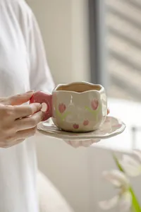 Detailed close-up of French vintage ceramic coffee cup with pink tulip floral patterns