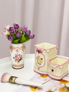 Dettaglio dell'organizzatore in resina con rose e trama intrecciata per pennelli