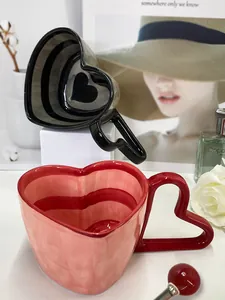 Detail of heart-shaped ceramic coffee mugs with striped patterns and heart-shaped handles