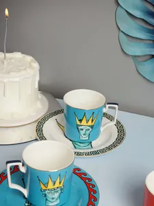 Dettaglio della tazza in ceramica celeste con motivo a greca e design a corona