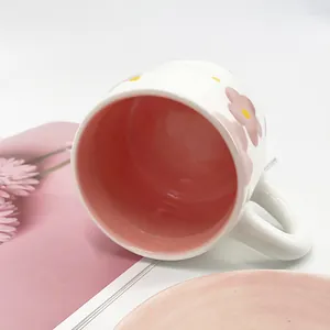 Close-up of a floral ceramic coffee mug showing the pink interior glaze and handle
