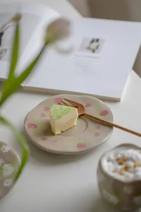 Detail of vintage ceramic plate with hand-painted tulips and wooden fork for dessert