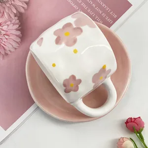Close-up of ceramic tea cup with pink floral patterns and matching saucer set