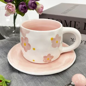 Detailed view of hand-painted pink floral ceramic coffee cup with matching saucer set