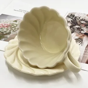Détail d'un ensemble tasse et soucoupe en céramique crème avec texture de coquillage