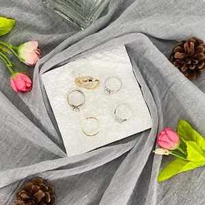 Bandeja de resina para joyas con anillos de oro y plata y detalles florales de circonita