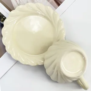 Détail d'une tasse et soucoupe en céramique crème avec une texture torsadée et fini brillant