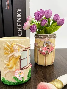 Dettaglio dei rilievi vintage di rose e angeli su porta pennelli in resina decorativa