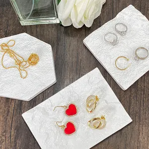 Vista superior de joyas de oro y plata sobre losas de piedra decorativa blanca