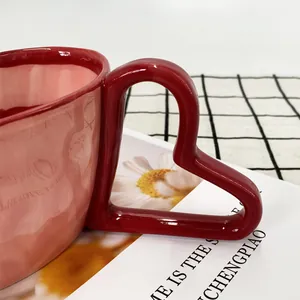 Detail of creative ceramic mug featuring a unique red heart-shaped handle and marble texture