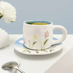 Detail of floral ceramic teacup with light blue glaze and fresh lemon drink inside