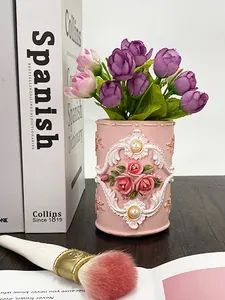 Dettaglio di un portapennelli in resina retrò con rose in rilievo e decoro europeo