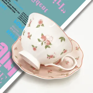 Close-up of pastoral ceramic coffee cup set with rose pattern and wavy edges