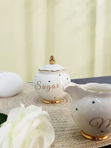 Detailed close-up of ceramic sugar bowl with gold rim and black polka dots design