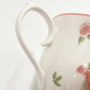 Macro detail of elegant ceramic handle featuring delicate pink rose floral patterns