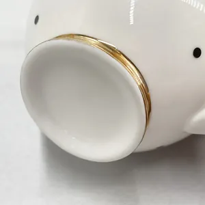 Macro detail of white ceramic base with black polka dots and gold-gilded rim finish