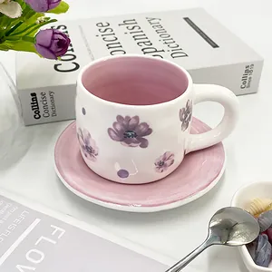 Detailed view of floral ceramic coffee cup with pink interior and matching saucer