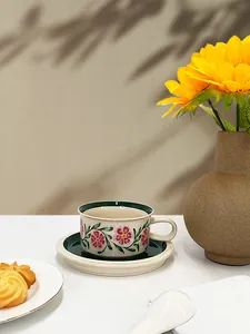 Detail of vintage floral ceramic coffee cup and saucer with pastoral pattern in sunlight