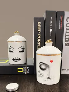 Détail de jarres en céramique blanche avec poignées dorées et motifs de visage artistique