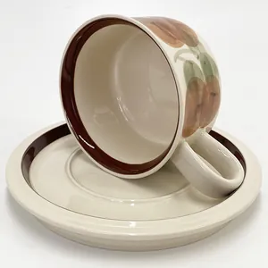 Detailed view of French vintage ceramic coffee cup with hand-painted fruit and stripes