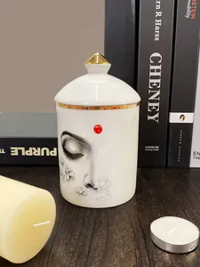 Détail d'un pot en céramique blanche avec motif yeux, fleurs et bordures dorées