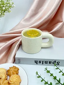Detail of Nordic ceramic mug with ink splash pattern and thick circular handle