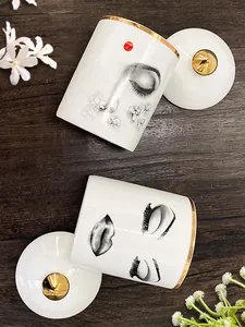 Détail du pot en céramique blanche avec bord doré et design artistique de visage