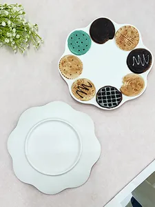 Detail view of wavy ceramic plate with colorful cookie patterns for afternoon tea