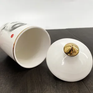 Détail du pot en céramique avec bord doré, couvercle à poignée sphérique et portrait