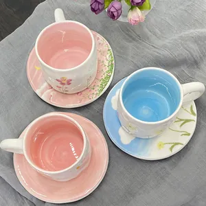 Pastel floral ceramic coffee cup and saucer set with textured interior and garden design