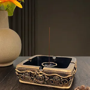 Detail of vintage bronze square incense burner with 3D rose carvings on dark wood table