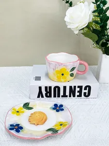 Détail d'un ensemble tasse et soucoupe en céramique peinte à la main avec fleurs