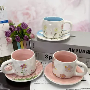 Detail of floral ceramic mug and saucer set with wavy texture and pastel glazed interior