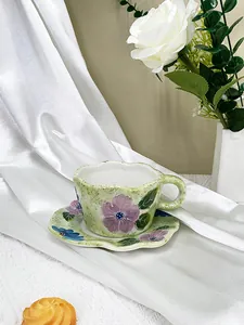 Gros plan d'un ensemble tasse à café et soucoupe en céramique peinte à la main