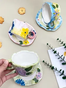 Détail d'une tasse et soucoupe en céramique peinte à la main avec motifs floraux