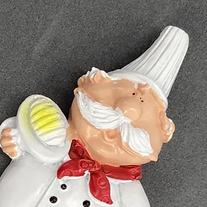 Macro detail of resin chef bottle opener with white hat and red bowtie on grey texture
