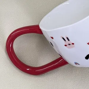 Primer plano de taza de cerámica con asa roja y estampado de conejo animado