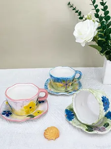 Vue détaillée des tasses à café en céramique peintes à la main avec bords ondulés