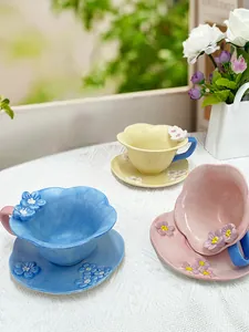 Macro shot of 3D floral ceramic coffee cups and petal saucers in pastel colors