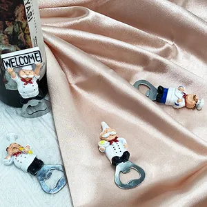 Macro detail of cartoon chef bottle openers with Welcome sign on decorative satin fabric