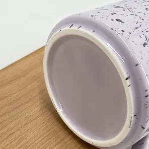 Detail of unglazed non-slip ring base on a purple splattered ceramic mug
